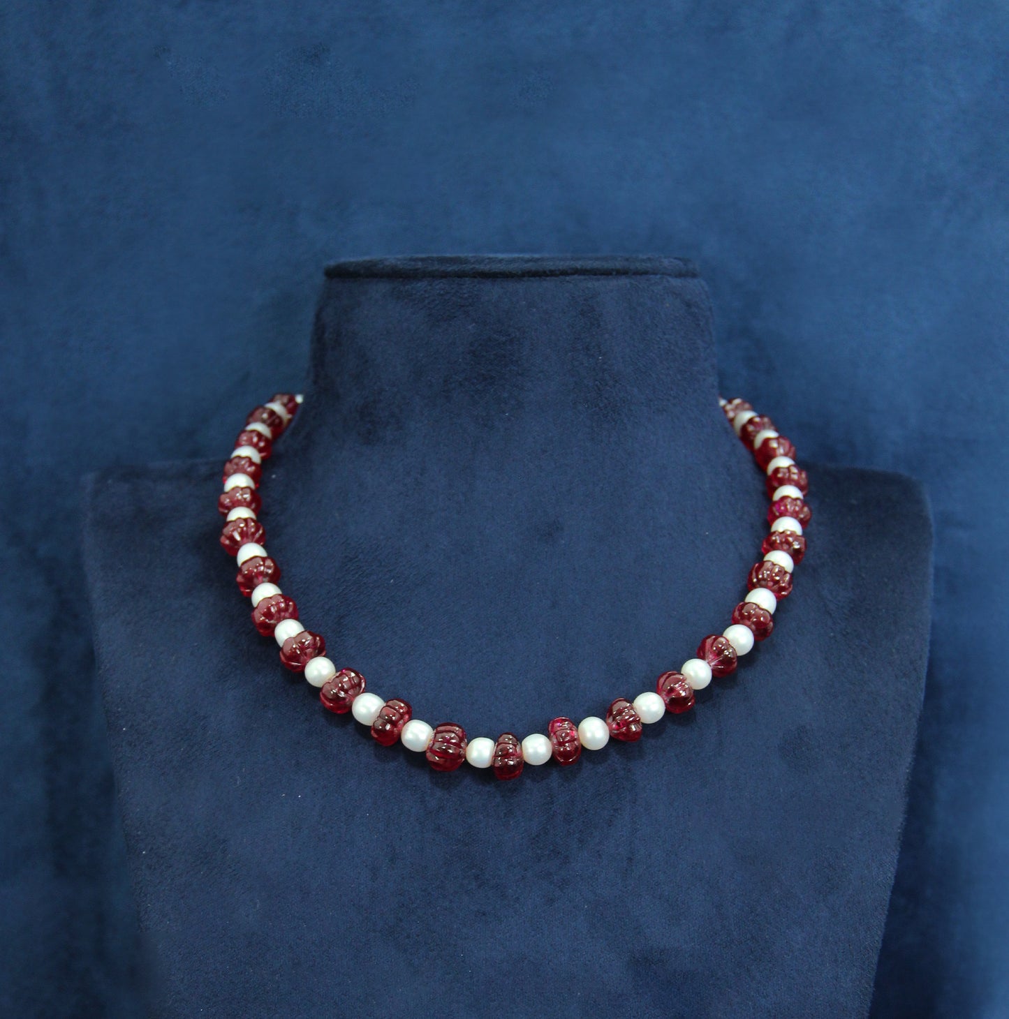 "Elegant single-line mala with white pearls and ruby-colored beads"