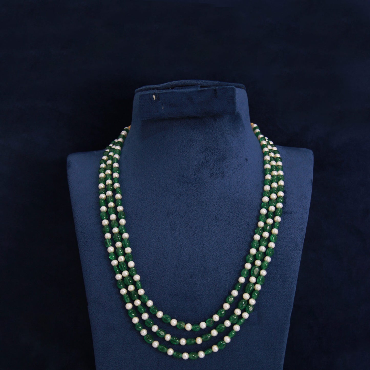Three-strand aesthetic necklace with white pearls and green beads for elegant festive wear.